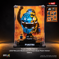LEGO Brick Land display case for a McLaren F1 Oscar Piastri helmet, featuring a clear acrylic case with a printed helmet graphic, a small LEGO minifigure, and a black base labeled PIASTRI, shown on a dark studio background with promotional sticker graphics.