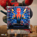 A clear acrylic display case featuring a Spider-Man bust design with a blue spiderweb pattern background and a red-and-blue Spider-Man figure mounted inside. The case is shown against a blurred cityscape and large Spider-Man artwork backdrop, with text identifying the product as an acrylic display case for LEGO Marvel Iron Spider-Man Bust (76326).